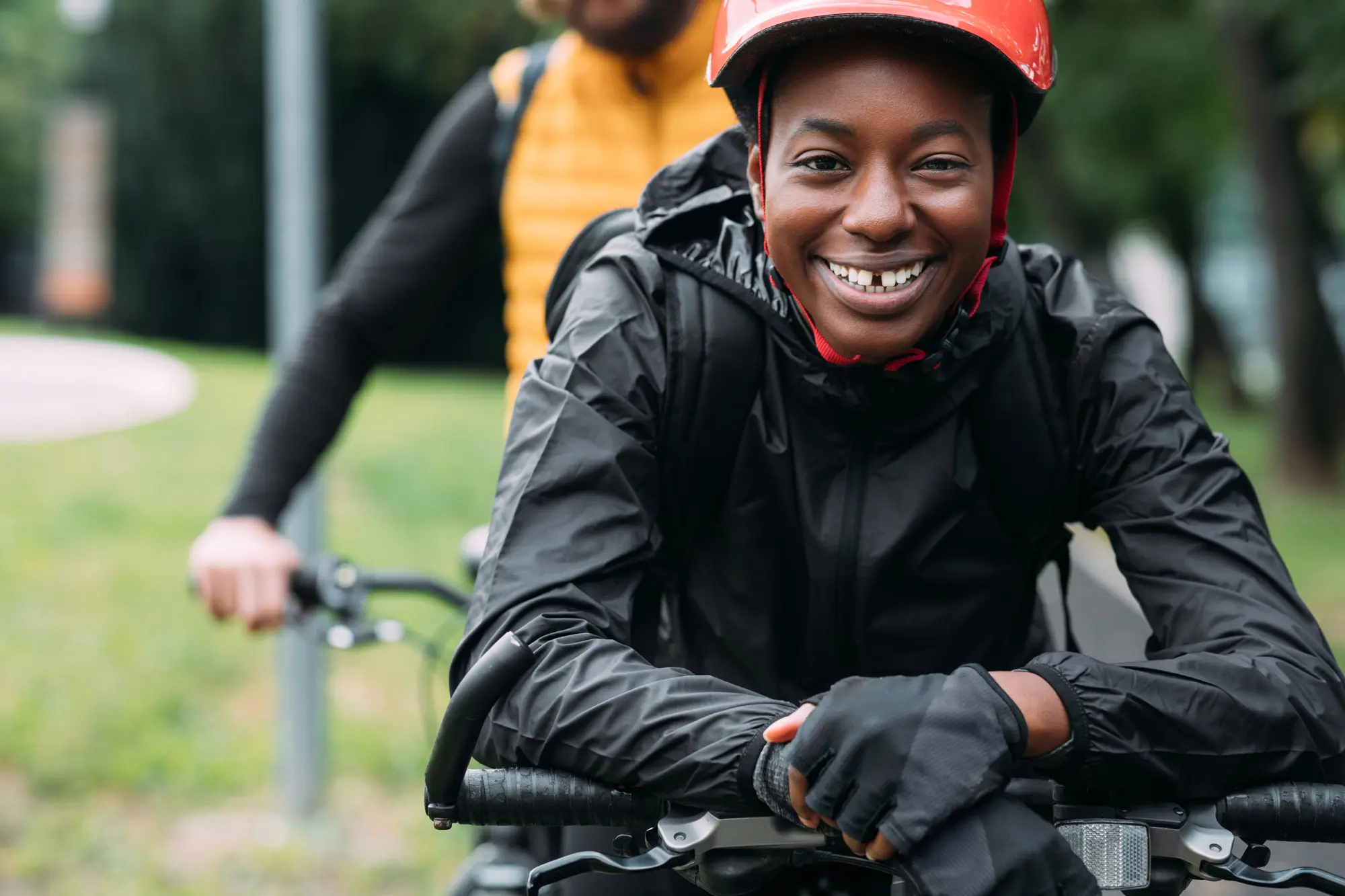 Smiling cyclist in red helmet on her bike in the city