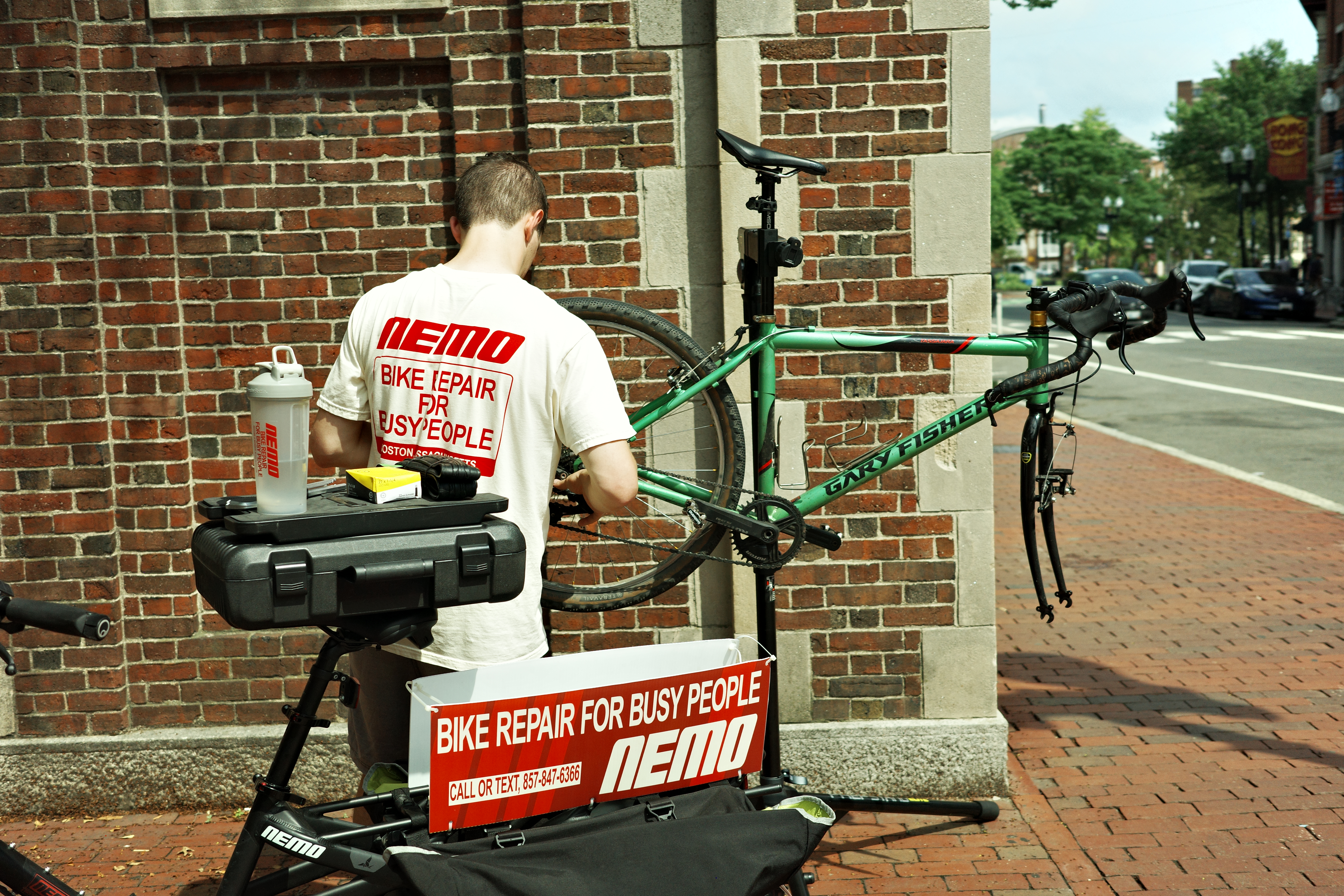 NEMO mechanic working at a repair stand with cargo bike in an urban setting